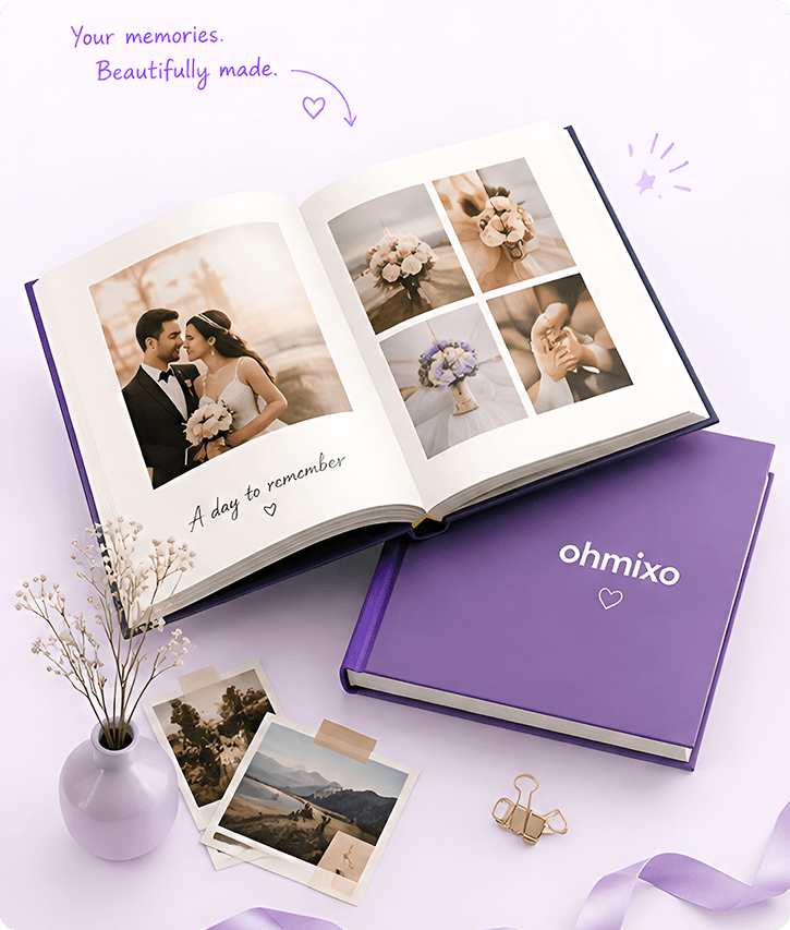 An open ohmixo photo book beside a small vase and printed photos